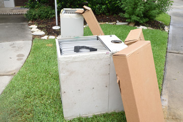 Old gas furnace units sitting at curb after technician has replaced units with new heaters