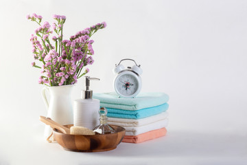 Shelf with clean towels, candles, flowerpot on bathroom white background