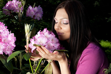 Naklejka premium woman smiling outdoors with some flowers
