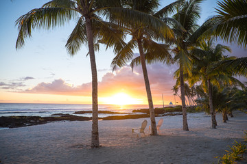 Two deck chairs under palm trees at sunset on an empty beach at Lefaga, Matautu, Upolu Island, Samoa, South Pacific