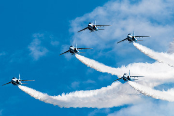Fototapeta na wymiar Blue Sky and aerobatics flying by five Jets.