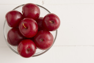 Fresh red plums, on white background.
