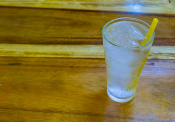 Water ice in the glass on the wooden table.