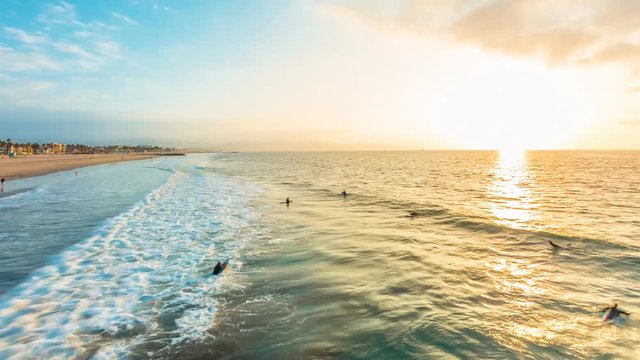 Sunrise time-lapse of Venice Beach, California with surfers and swimmers