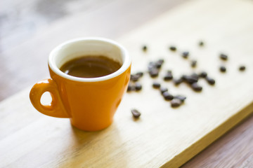 coffee cup and coffee beans on wood