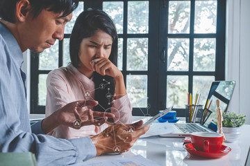 Mature businessman using a digital tablet to discuss information with a younger colleague.