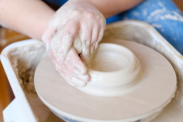 pottery handicraft skills. traditional art of creating ceramics. potter modeling clay on turning wheel