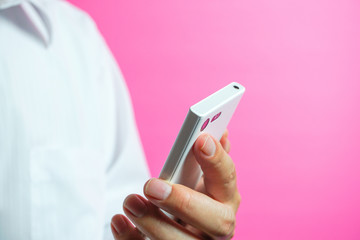 Person using a smartphone スマートフォンを使っている人　ピンク色背景