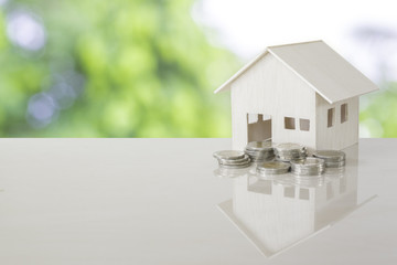 House model and coin money on table.