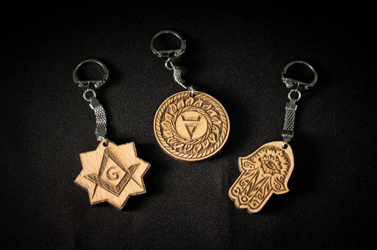 Amulets made of wood with a metal hook on a black background