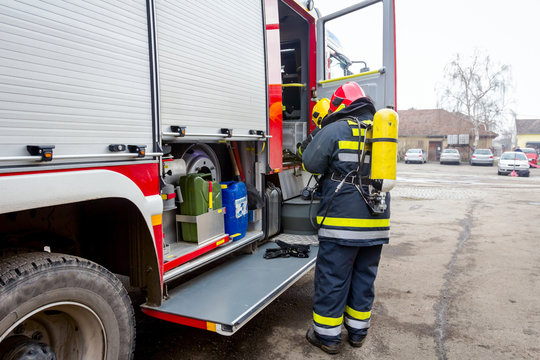 Fireman is helping colleague to manage full safety gear