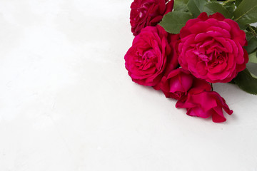 A bouquet of red roses on a light stone background. Flat lay, top view