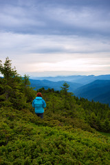 Fototapeta premium Adventurer female is standing on the mountain slope