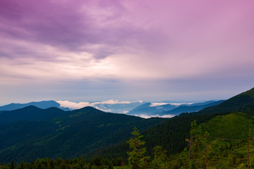 Heavy clouds are floating above the wooded hills