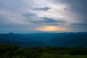Heavy clouds floating above the green hills