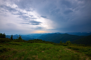 Heavy clouds float above the green hills