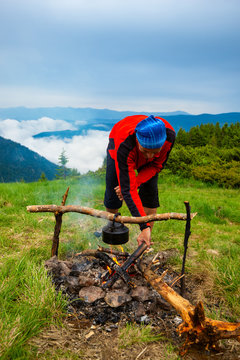 Adventurer throws firewood in the bonfire