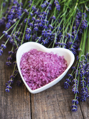 Obraz na płótnie Canvas Heart-shaped bowl with sea salt and fresh lavender flowers