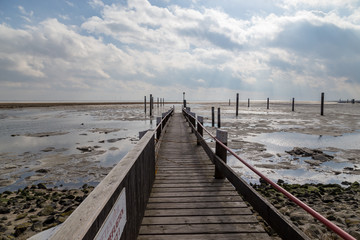 Steg und Dalben im Spiekerooger Hafen bei Eisgang im Winter