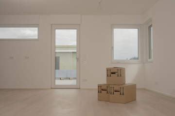 Moving Day at Home - brown packaging boxes in empty room with windows