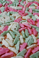 Colorful chewing foam candies in shape of car on wooden table as textured sweet  background.