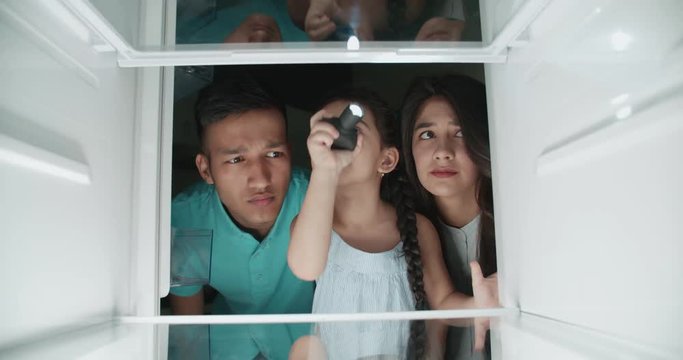 sad asian family looking in empty refrigerator, searching for products and finds nothing...