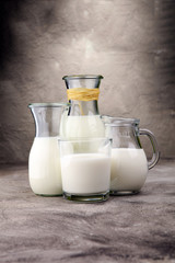 A jug of milk and glass of milk on a table