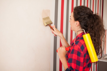 repair, building and home concept - close up of woman smearing wall with glue