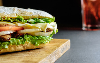 big sandwich with pink drink cocktail on background Street food, fast food. Homemade burgers with beef, cheese  on the wooden table. Toned image.