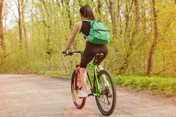 Active life. Sport girl trailing on a bike enjoys the view of sunset over an forest. Heathy lifestyle concept. Text placement