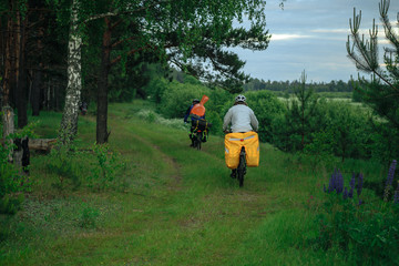 Bicyclists on the country road in village in the evening