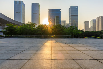 Fototapeta premium Empty square floor and modern commercial building at sunrise in Shenzhen