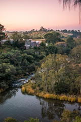 View looking over a lake and river winding between hills during sunset