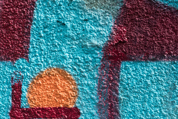 Fototapeta na wymiar Orange and red graffiti details on a blue painted wall, facade. Abstract background, wallpaper.