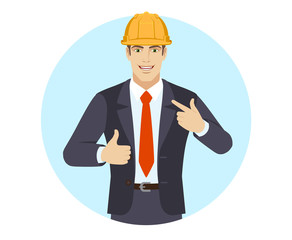 Businessman in construction helmet  showing thumb up and  pointing the finger at himself