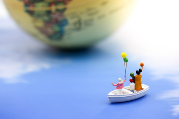 Miniature people : family relaxing in floating in the water.
