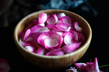 Close-up macro photo of rose petals in a wooden bowl