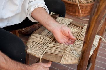 Repairing an old wood chair with straw