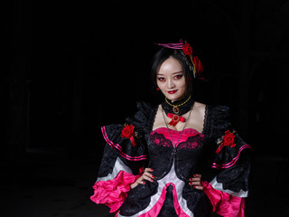 Photo of a female vampire dressed in black and red Longuette, standing on bloody road with red eyes...