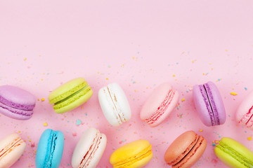 Macaron or macaroon on pink pastel background top view. Flat lay composition.