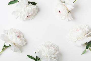 Wedding frame of beautiful white peony flowers on pastel table top view. Flat lay style.