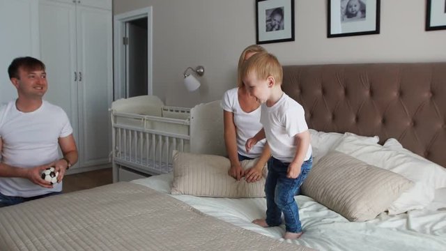 Parents having fun with their little daughter on bed. Family spending time at the morning