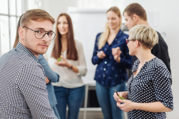 Portrait of young man in office team meeting