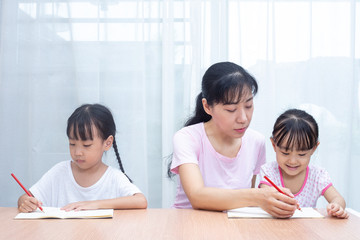 Asian Chinese mother teaching daughters doing homework