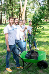 young volunteers with new trees in wheelbarrow