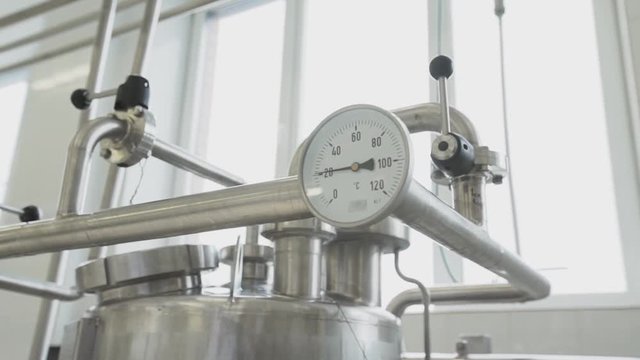 Little white thermometer of pasteurizer tank with marks froze at around twenty degrees Celsius