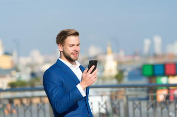 Businessman use smartphone with smile. Happy man with mobile phone on sunny terrace. Great business...