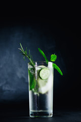 Fresh Summer Drink. Healthy glass detox fizzy water with lemon, mint, rosemary and cucumber in mason jar over dark background. Healthy food concept. Detox diet.