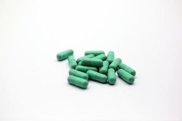 Green capsules pill isolated in white background. Closeup green drug for health or pharmaceutical concept.