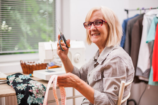Adult woman is sewing in her studio.